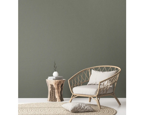 Wohnzimmer mit Rattansessel, Beistelltisch aus Holz und rundem Teppich