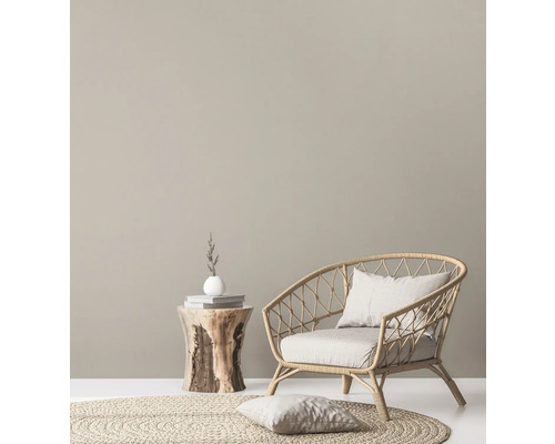 Dekoratives Wohnzimmer mit Rattansessel, Holztisch und rundem Teppich