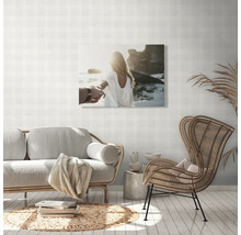 Wohnzimmer mit Sofa, Stuhl und Wandbild mit Strandmotiv