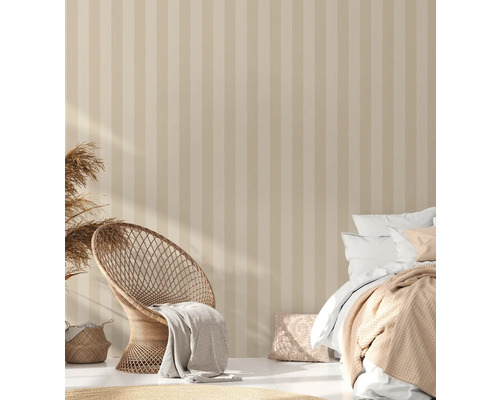 Helles Schlafzimmer mit gestreifter Tapete, Korbsessel und Bett