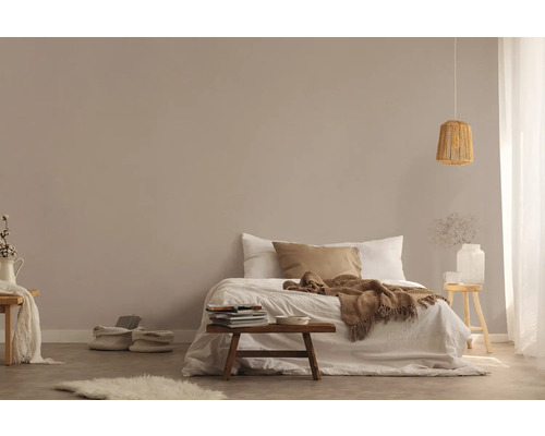 Helles Schlafzimmer mit Bett, Holzhocker und Rattanhängelampe für eine freundliche Atmosphäre.