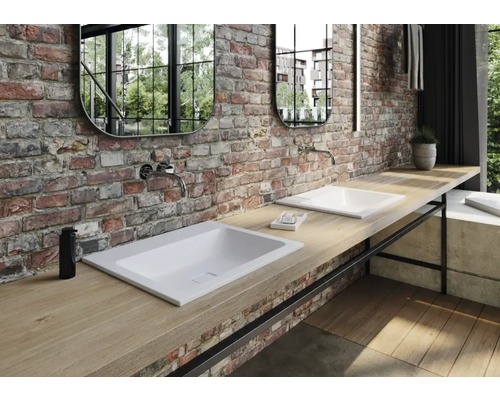 Badezimmer mit zwei Aufsatzwaschbecken auf einer Holzplatte vor einer Ziegelwand