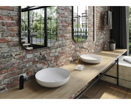 Badezimmer mit zwei Aufsatzwaschbecken, zwei Spiegeln und einer Wand aus Ziegelsteinen.