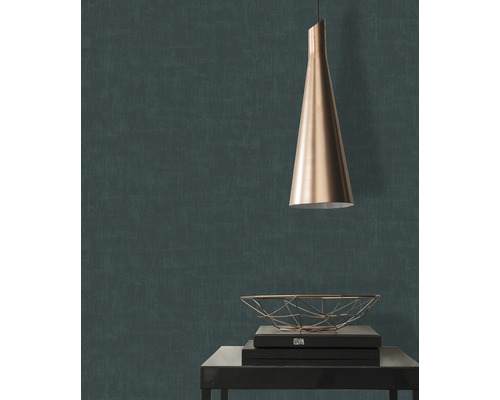 Nahaufnahme einer dunkelgrünen Strukturtapete mit einer Pendelleuchte