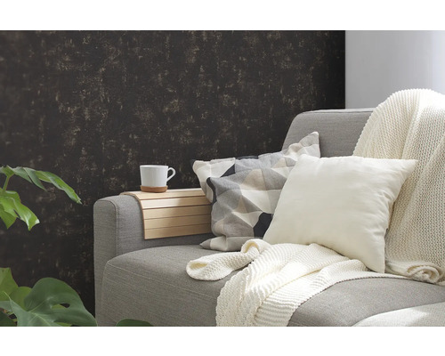 Gemütliche Sitzecke mit Sofa, Kissen, Decke und einer Tasse auf einem Holztablett