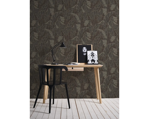 Dekorative Wand mit Blättertapete hinter einem Schreibtisch mit Stuhl.