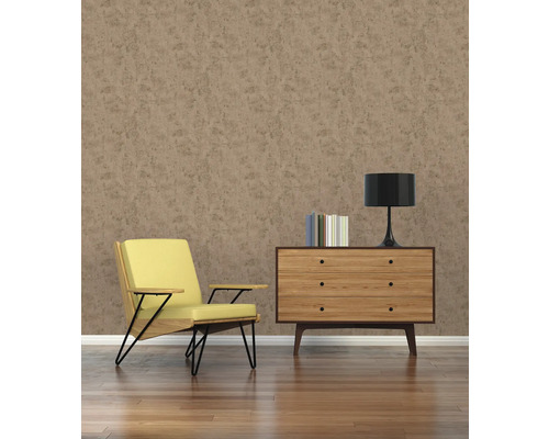 Wohnzimmer mit Sessel, Kommode, Lampe und Büchern vor einer braunen Wand