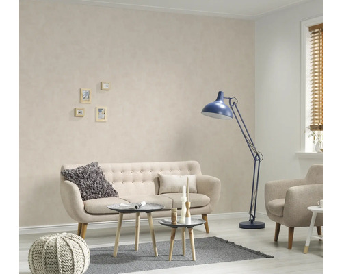 Wohnzimmer mit Sofa, Sessel, Stehlampe und kleinen Tischen auf einem Teppich