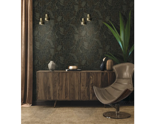 Wohnzimmer mit gemusterter Tapete, Kommode, Sessel und Zimmerpflanze