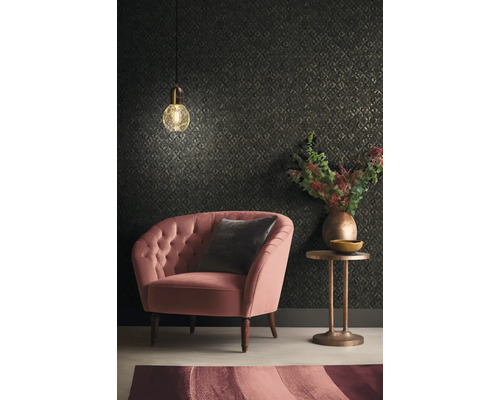 Wohnzimmer mit Sessel, Kissen, Beistelltisch, Lampe und gemusterter Tapete.