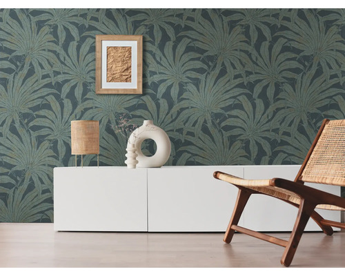 Wohnzimmer mit gemusterter Tapete, weißem Schrank, Lampe, Deko und Holzstuhl