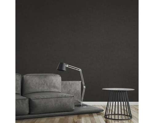 Wohnzimmer mit Sofa, Stehlampe und Beistelltisch vor dunkler Wand