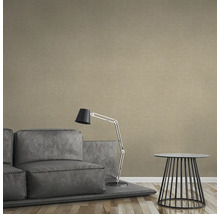 Beige Vliestapete in einem Wohnzimmer mit Sofa, Lampe und Tisch.