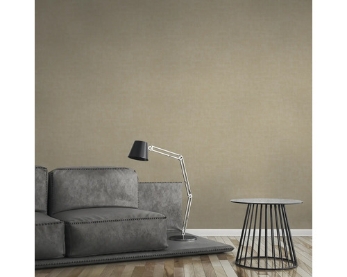 Beige Vliestapete in einem Wohnzimmer mit Sofa, Lampe und Tisch.