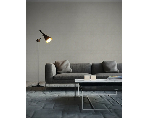 Wohnzimmer mit Sofa, Stehlampe und Couchtisch auf einem Teppich