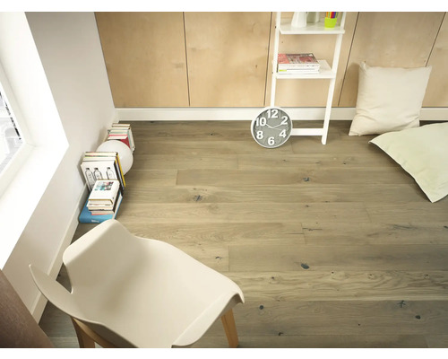 Heller Raum mit Holzboden, Leiterregal, Uhr, Kissen und Stuhl.