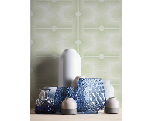 Arrangement verschiedener Vasen vor einer gemusterten Tapete