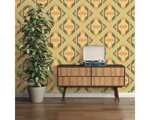 Wohnzimmer mit gemusterter Tapete, Kommode und Zimmerpflanze