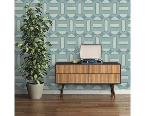 Wohnzimmer mit gemusterter Tapete, Holzkommode, Schallplattenspieler und Zimmerpflanze