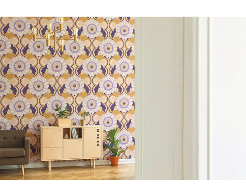 Wohnzimmer mit gemusterten Tapeten, Schrank, Sessel, Zimmerpflanze und Stehlampe