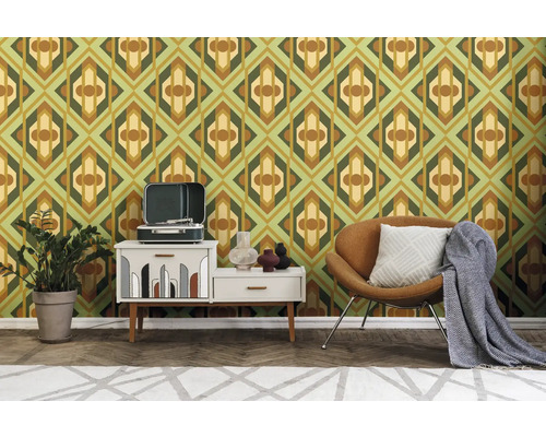 Retro-inspirierte Wohnraumgestaltung mit grafischer Tapete, Plattenspieler auf Kommode, Sessel und Zimmerpflanze.