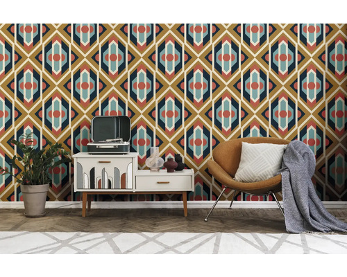 Raumansicht mit gemusterter Tapete, Sessel, Kommode und Dekoration