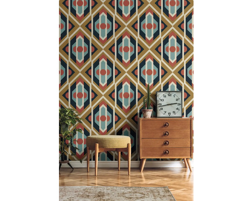 Wohnzimmer mit gemusterter Tapete, Kommode, Hocker, Zimmerpflanzen und Teppich