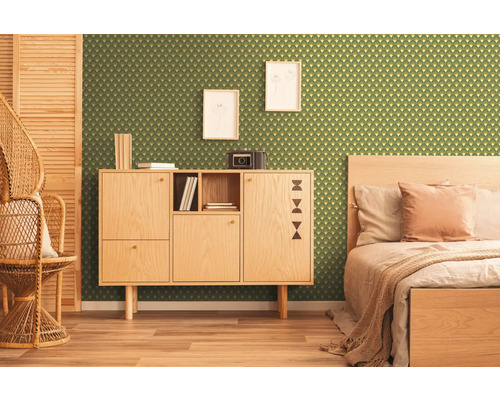 Zimmer mit grüner Tapete mit geometrischem Muster, Holzschrank, Bett und Korbstuhl.