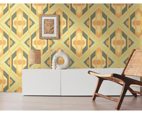 Raumansicht mit gemusterter Tapete, Kommode, Dekoration und Stuhl