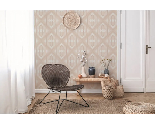 Dekoratives Wohnzimmer mit gemusterter Tapete, Rattansessel und Holzboden