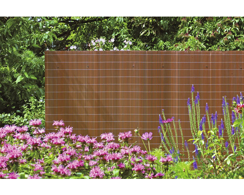 Blick auf einen Gartenzaun aus Bambus mit Blumen