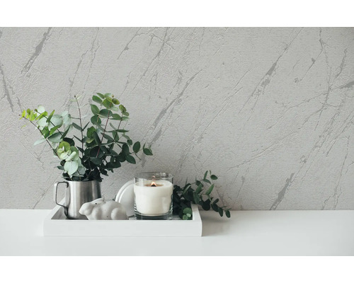 Dekorative Szene mit Zimmerpflanze, Kerze und Marmortapete