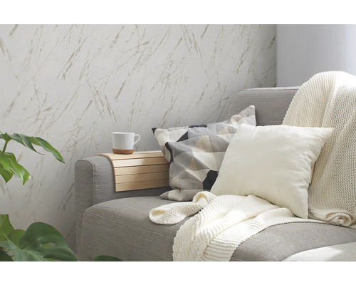 Wohnzimmer mit grauer Couch, Kissen, Decke, Beistelltisch und Tapete mit Marmormuster.