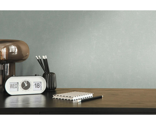 Nahaufnahme eines Schreibtisches mit Lampe, Kalender, Stiften, Notizbuch und Tapete