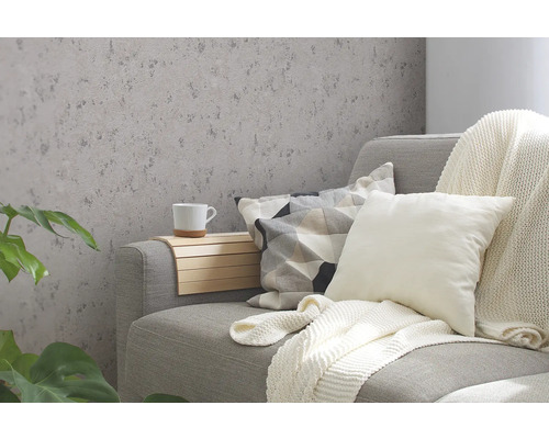 Dekoratives Wohnzimmer mit gemusterter Tapete, Sofa, Kissen und Pflanzen