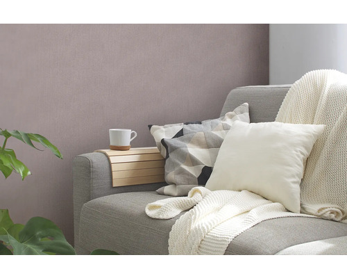 Gemütliche Wohnzene mit Sofa, Kissen, Decke und Beistelltisch