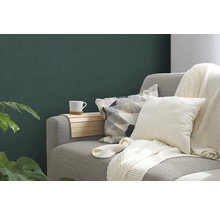 Wohnzimmerszene mit grauer Couch, Kissen, Decke, Holztablett und Tasse