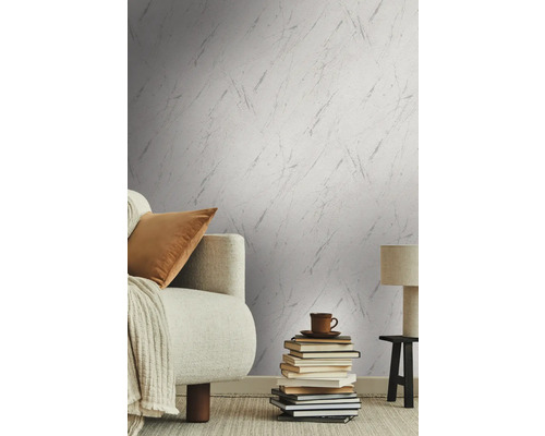 Wohnzimmer mit gemusterter Tapete, Sofa, Büchern, Tischlampe und Teppich für eine gemütliche Atmosphäre