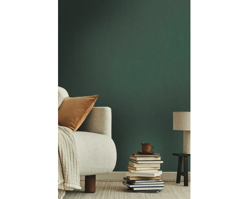 Wohnzimmer mit Sessel, Bücherstapel und Lampe