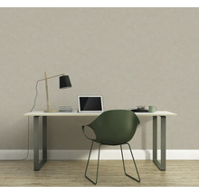 Arbeitszimmer mit Schreibtisch, Lampe, Laptop und Stuhl vor einer strukturierten Tapete