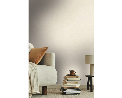 Wohnzimmer mit Sofa, Bücherstapel und gemusterter Tapete