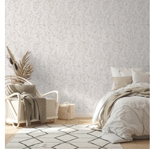 Helles Schlafzimmer mit floral gemusterter Tapete, Sessel und Bett