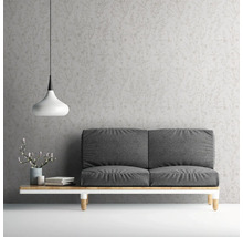 Wohnzimmer mit grauer Couch, Lampe und gemusterter Tapete