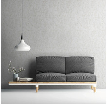 Wohnzimmer mit grauer Couch, Lampe und gemusterter Tapete