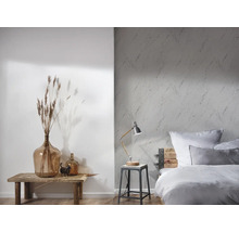 Helles Schlafzimmer mit gemusterter Tapete, Holzbett und dekorativen Elementen auf einem Holztisch
