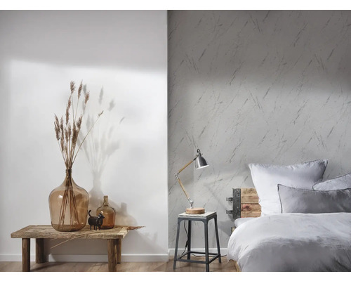 Helles Schlafzimmer mit gemusterter Tapete, Holzbett und dekorativen Elementen auf einem Holztisch