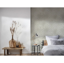 Schlafzimmer mit Bett, Tischlampe und gemusterter Tapete
