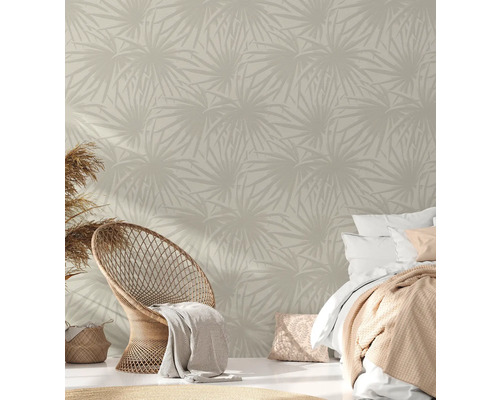 Schlafzimmer mit gemusterter Tapete, Rattansessel und Bett