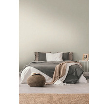 Schlafzimmer mit Bett, Nachttisch, Teppich und Hocker für eine gemütliche Atmosphäre