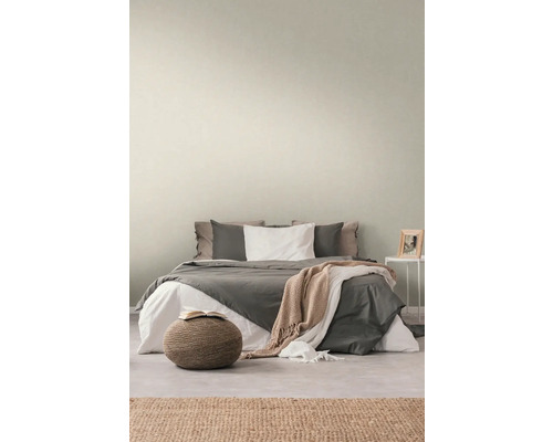 Schlafzimmer mit Bett, Nachttisch, Teppich und Hocker für eine gemütliche Atmosphäre